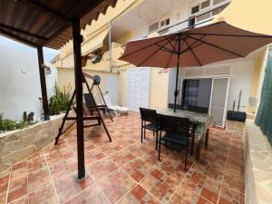a patio with a table and an umbrella at Beach Paradise Apartment in Adeje