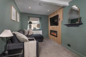 a living room with a couch and a fireplace at Gibson Cottage in Penrith