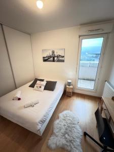 Schlafzimmer mit einem Bett, einem Fenster und einem Teppich in der Unterkunft Standing, balcon avec vue, clim, tt équipé confort in Échirolles