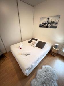 ein Schlafzimmer mit einem weißen Bett in einem Zimmer in der Unterkunft Standing, balcon avec vue, clim, tt équipé confort in Échirolles