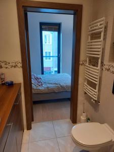 a bathroom with a mirror with a bed and a toilet at Apartment with an Amazing View in Gdańsk