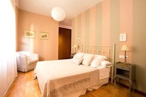 - une chambre avec un lit et des oreillers blancs dans l'établissement Apartamento Ría San Esteban, à San Esteban de Pravia