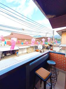 a bar with two stools and a clock on a ledge at PAI BAAN Homestay ปายบ้าน โฮมสเตย์ ถนนคนเดินปาย in Pai