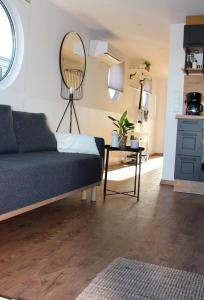 a living room with a couch and a mirror at Hausboot - Nordsonne 11 in Wangerland