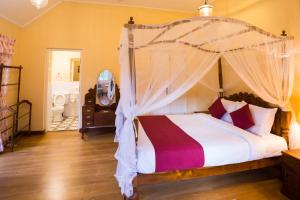 ein Schlafzimmer mit einem Himmelbett in der Unterkunft Rockbourne Bungalow in Kandy