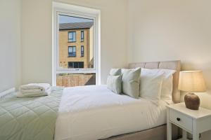 a white bedroom with a bed and a window at Home from Home - Mersey Way, Spacious 3 Bed, Perfect for Workers, Groups & Families, Netflix, FREE Parking & EV Charge Point in Sheffield