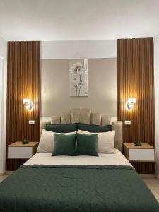 ein Schlafzimmer mit einem großen Bett mit grünen und weißen Kissen in der Unterkunft Feti Xhone Apartment in Ksamil