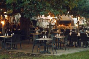 a restaurant with tables and chairs under a tree at A Machja in Olmiccia