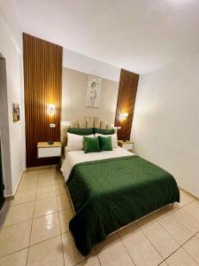 ein Schlafzimmer mit einem großen Bett und einer grünen Decke in der Unterkunft Feti Xhone Apartment in Ksamil