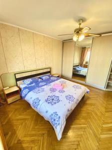 - une chambre avec un lit et une couette bleue et blanche dans l'établissement Апартаменти поруч з метро Лівобережна та МВЦ, à Kiev