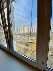 Апартаменти поруч з метро Лівобережна та МВЦ في كييف: نافذة مفتوحة مطلة على المدينة