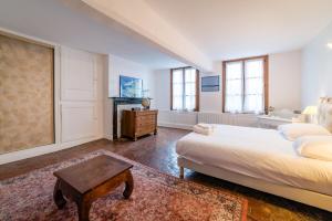 1 dormitorio con cama, mesa y ventanas en Home - Michelet - Séjour à Auxerre en Auxerre