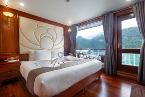 ein Schlafzimmer mit einem großen Bett und einem großen Fenster in der Unterkunft Le Journey Calypso Pool Cruise Ha Long Bay in Hạ Long