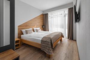 1 dormitorio con cama y ventana grande en Gogi Ski Resort en Gudauri