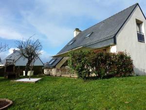 een wit huis met een dak en een groene tuin bij maison pluvigner in Pluvigner