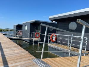ein Haus am Wasser neben einem Dock in der Unterkunft Hausboot - Nordsonne 11 in Wangerland
