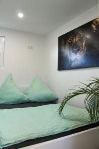 ein Schlafzimmer mit einem Bett und einem Gemälde an der Wand in der Unterkunft Hausboot - Nordsonne 11 in Wangerland
