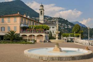 einen Brunnen vor einem Gebäude mit einem Uhrturm in der Unterkunft CASA DI MILO in Cernobbio