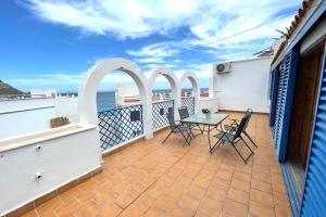 a patio with a table and chairs on a balcony at Apartamentos Vela Blanca in San José