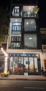 a tall building with windows and a building with lights at Homestay Lucas's House in Liên Trì (3)