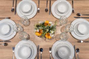 a table with white plates and wine glasses and flowers at Open Mind Property - 5 Bedroom Lovely Home with Free Parking in Portsmouth