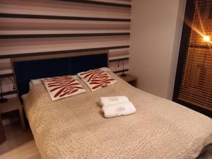 a bedroom with a bed with two towels on it at Apartment with an Amazing View in Gdańsk