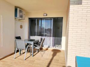 d'une salle à manger avec une table, des chaises et une fenêtre. dans l'établissement Panoramica Golf Karilo, à Sant Jordi