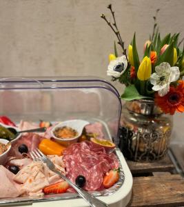 ein Tablett mit Lebensmitteln mit Fleisch, Gemüse und Blumen in der Unterkunft Hotel Haus Loewe in Frechen