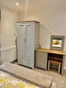 a bedroom with a desk and a cabinet and a table at No.8 - Garden Square in Banbury
