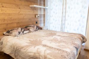 ein Bett in einem Schlafzimmer mit einer Holzwand in der Unterkunft High-end apartment 6 people capacity - Haut Combloux in Cordon