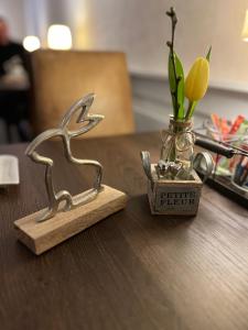 Une petite figurine d'un oiseau et d'un vase sur une table dans l'établissement Hotel Haus Loewe, à Frechen