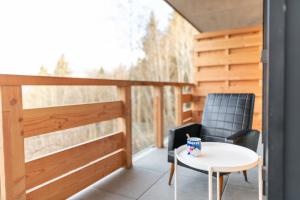 einen Balkon mit einem Tisch, 2 Stühlen und einem Fenster in der Unterkunft High-end apartment 6 people capacity - Haut Combloux in Cordon