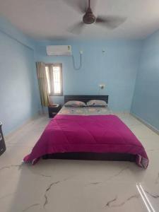 a bedroom with a purple bed in a blue room at The Breezy Place in Chennai