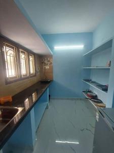 a kitchen with blue walls and a counter and a sink at The Breezy Place in Chennai