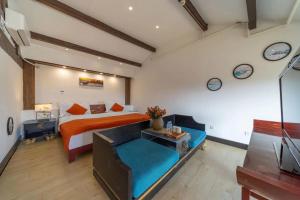 um quarto com uma cama e um sofá e relógios na parede em Lijiang Mountain View Boutique Inn em Lijiang