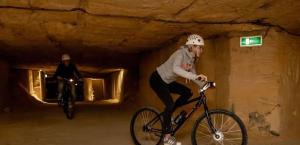 un hombre montando una bicicleta en un túnel en 6-pers vakantiebungalow in het Heuvelland, en Simpelveld