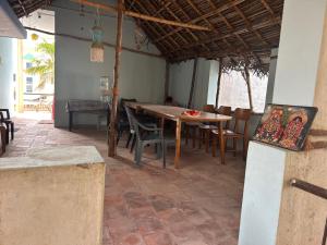 ein Esszimmer mit einem Holztisch und Stühlen in der Unterkunft ANBU RAMANA Guest House in Tiruvannāmalai