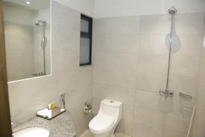 a white bathroom with a toilet and a sink at Trivelles Executive Suites Islamabad in Islamabad