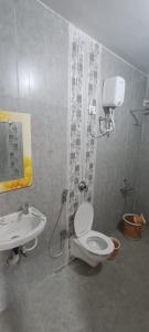 uma casa de banho com um chuveiro, um WC e um lavatório. em RAJ RESORT & BANQUETS em Vapi