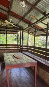 een houten picknicktafel in een overdekte veranda bij Banlaw Garden Resort in Puerto Princesa City