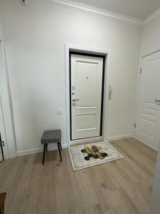 a room with a door and a chair and a rug at Aksay distr in Almaty