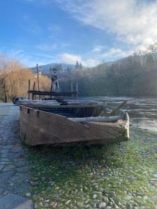 La Chaumière de Charly في آرْجونتا: قارب قديم يجلس على جانب النهر