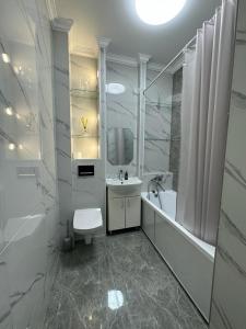 a white bathroom with a sink and a toilet at Aksay distr in Almaty
