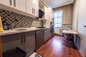 a kitchen with stainless steel appliances and a wooden floor at Best Location-Taksim Square Big and Modern Flat 140 (m2) 2+1 in Istanbul