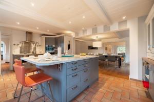 a large kitchen with a blue island in a room at Holsteinhof in Nieblum