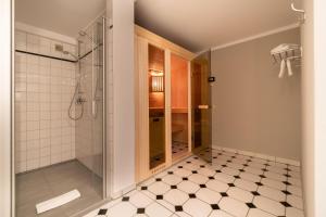 a bathroom with a shower and a tiled floor at Holsteinhof in Nieblum +61 photos