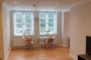 a dining room with a table and chairs and windows at No.9 - Park Place in Banbury