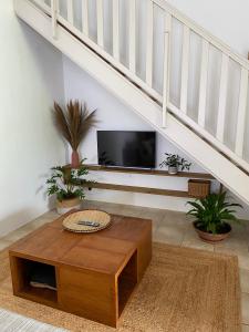 a living room with a tv and a wooden coffee table at kaz Lé pa si Ô in La Rivière