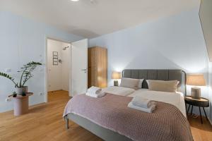 1 dormitorio con 1 cama grande y 2 toallas. en ma suite - cozy apartment 2P - best location - private Parking en Augsburg
