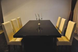 tavolo nero da pranzo con sedie bianche e candelabro di Sompoli Dthan a Siem Reap